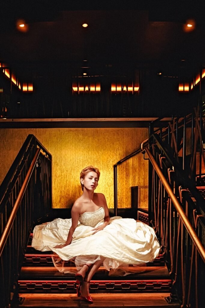 Dramatic bride portrait on dark staircase, cinematic moody lighting, gold texture backdrop in Indianapolis.
