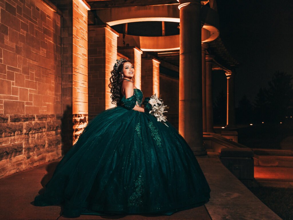 Quinceanera in sparkling emerald gown, cinematic night lighting and moody fine art aesthetic at Coxhall Gardens.