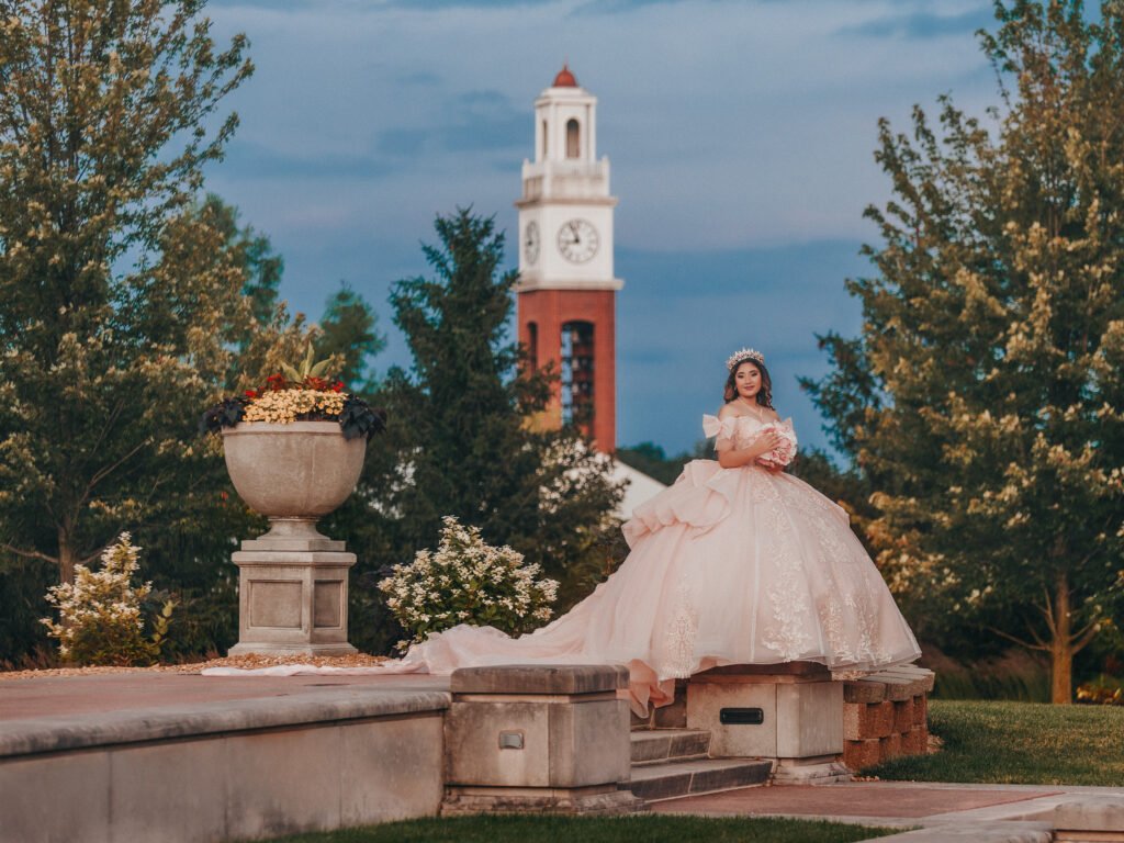 Dramatic Quinceanera portrait at Coxhall Gardens Clock Tower during twilight, fine art aesthetic.