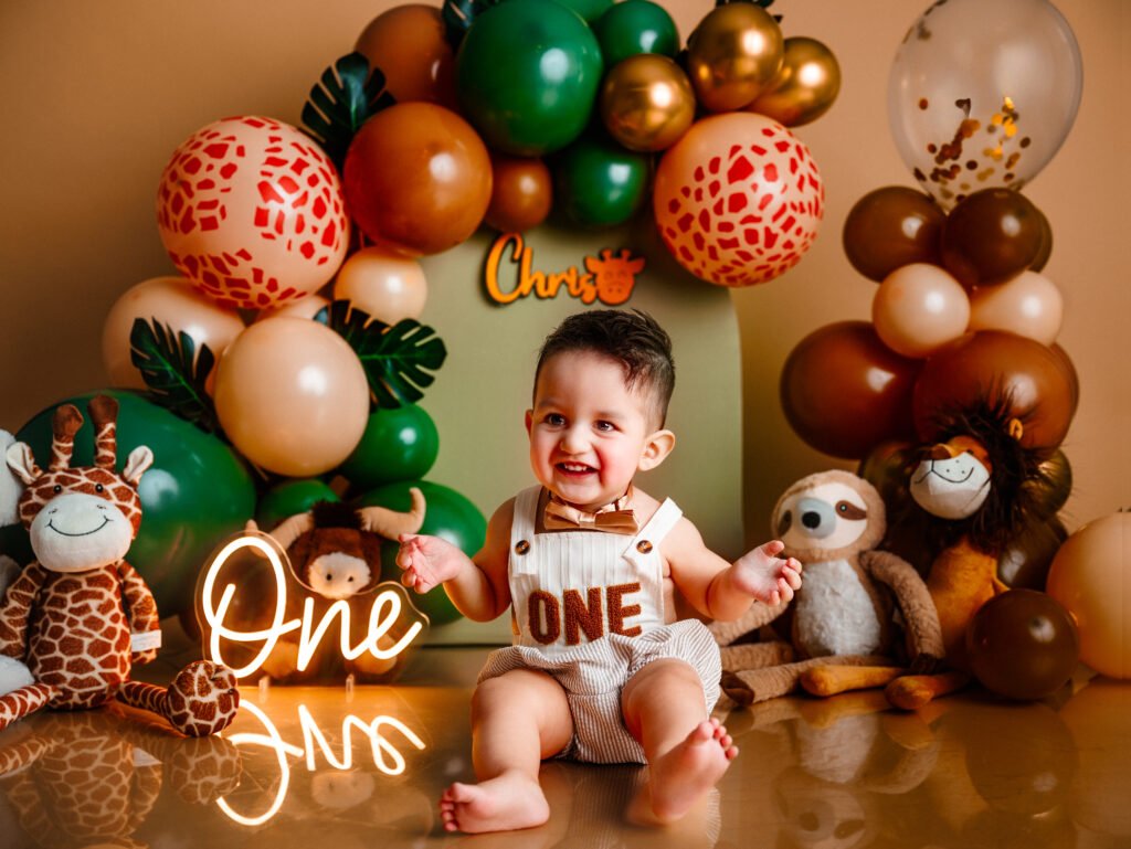 "Set de Cake Smash tema jungla y safari diseñado a medida con animales de peluche y globos verdes en Indiana".