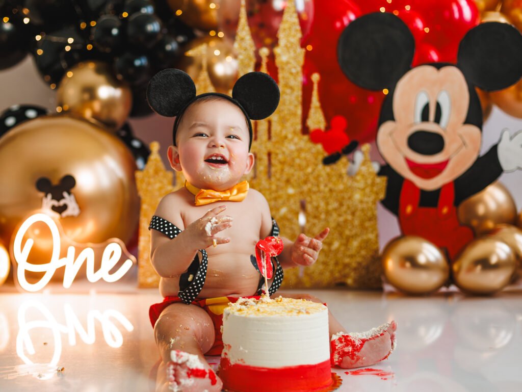 Toddler exploring his superhero-themed birthday set for a Mickey Mouse Cake Smash Photography session.