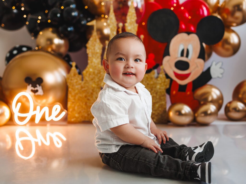 Professional Mickey Mouse Cake Smash Photography in Indianapolis featuring a gold and red set.